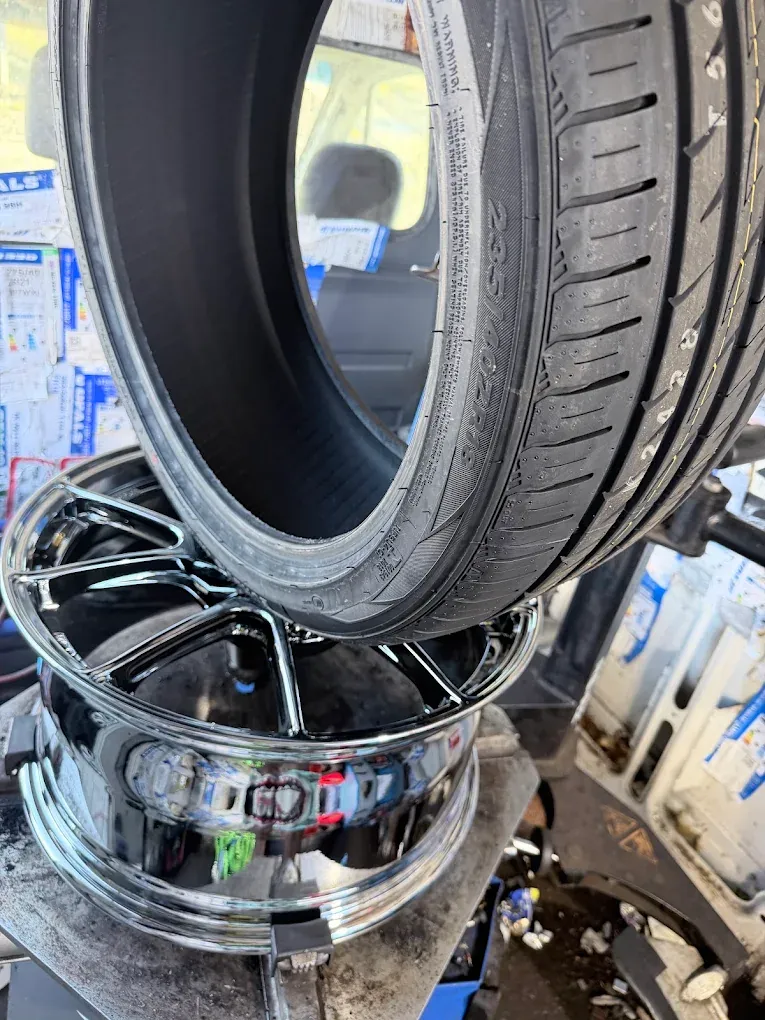 Close-up of a performance tyre and chrome rim ready for fitting